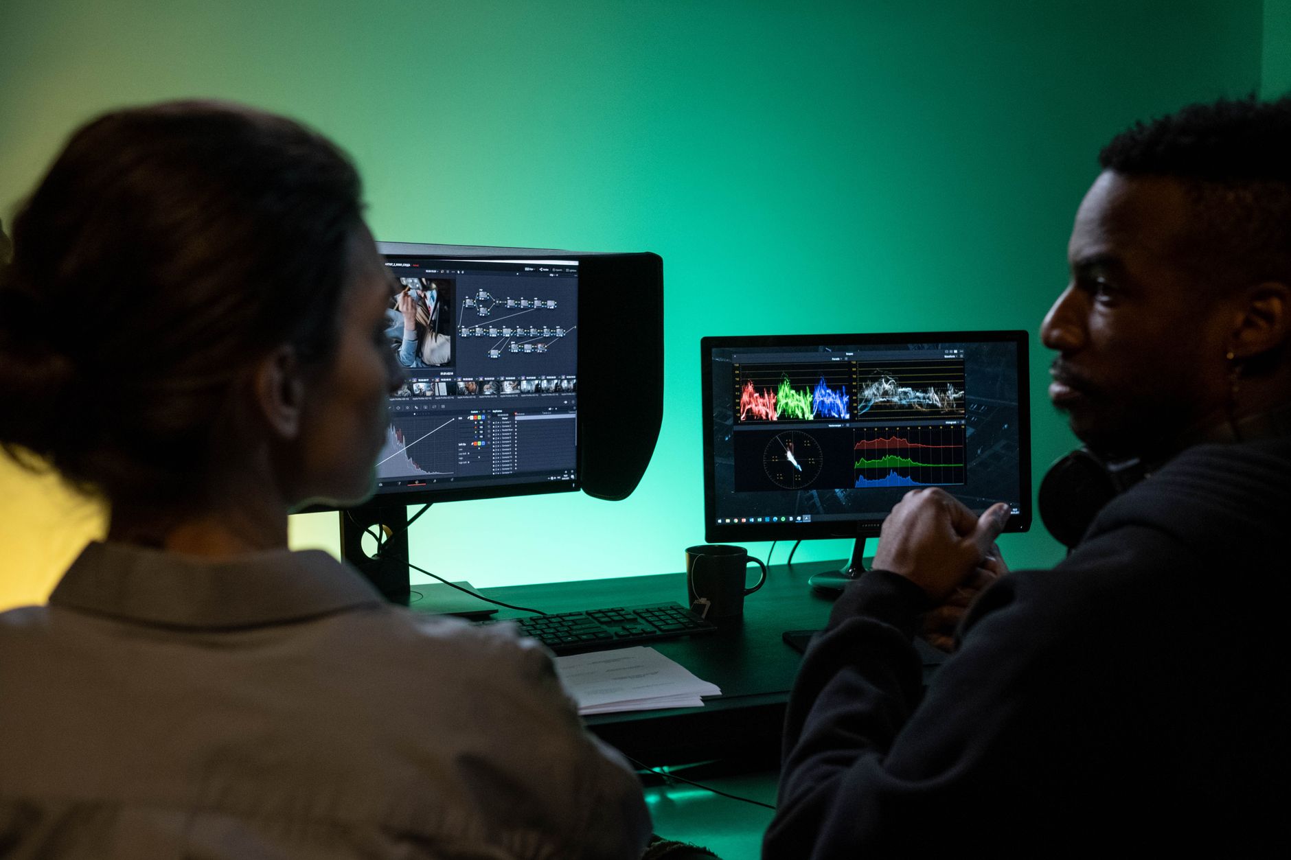 a person configuring an automation workflow on dual monitors with connected nodes on screen