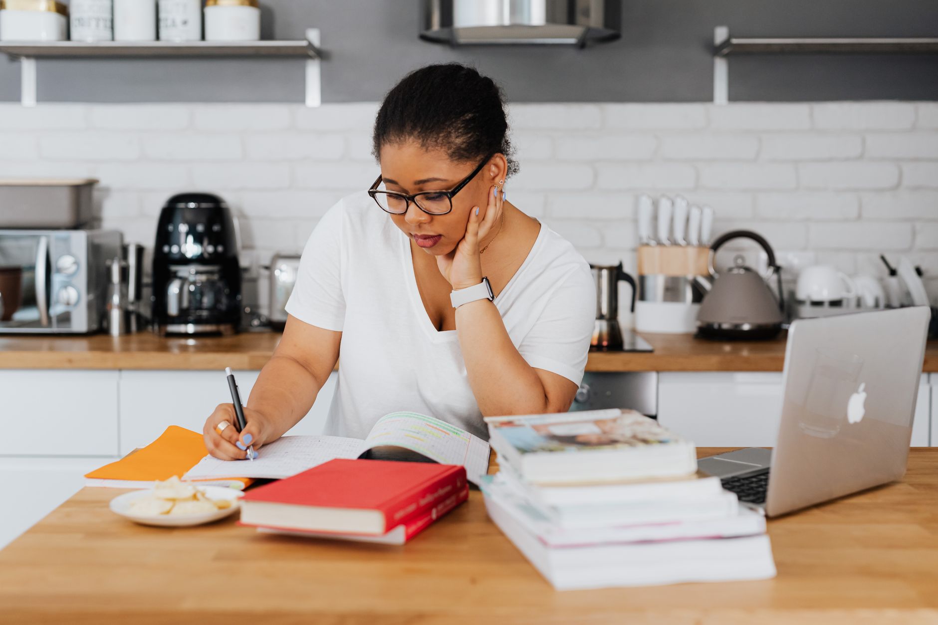 a cleaning business owner typing notes on a laptop at a kitchen table