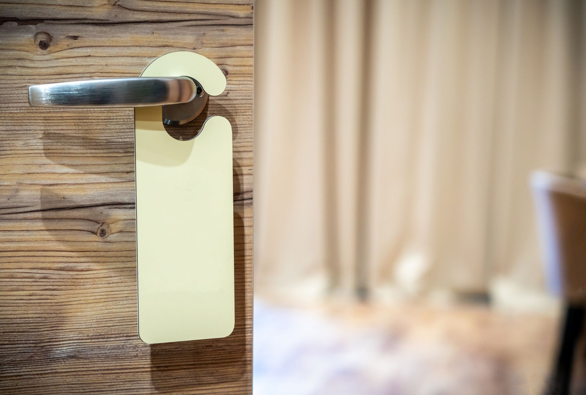 a man placing a cleaning service door hanger on a front door