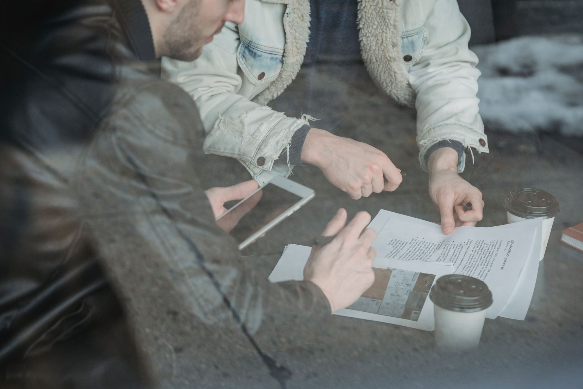 A teacher reviewing AI generated lesson plans on a tablet while drinking coffee at a desk
