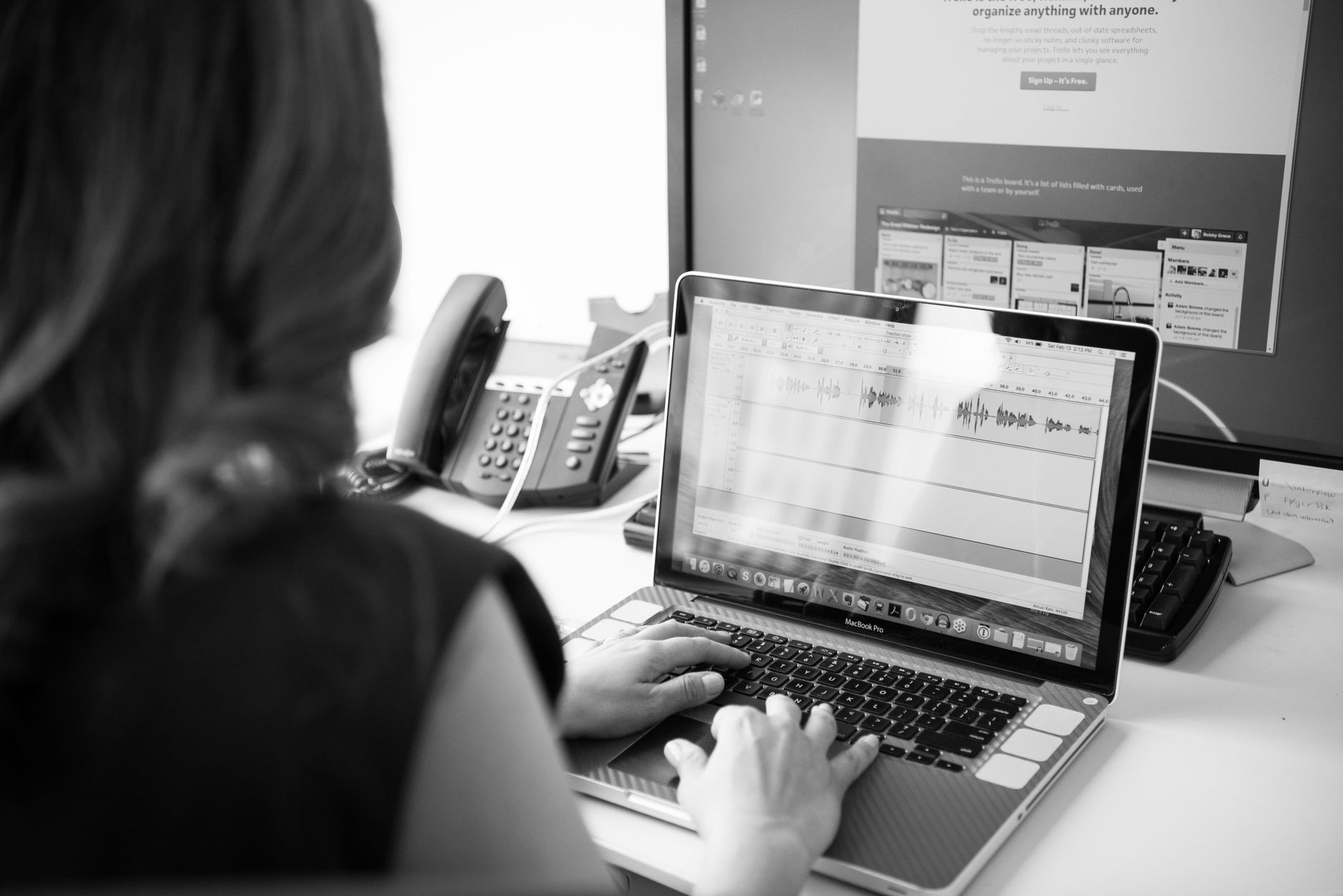 A person editing a long document on a laptop with a second monitor showing text