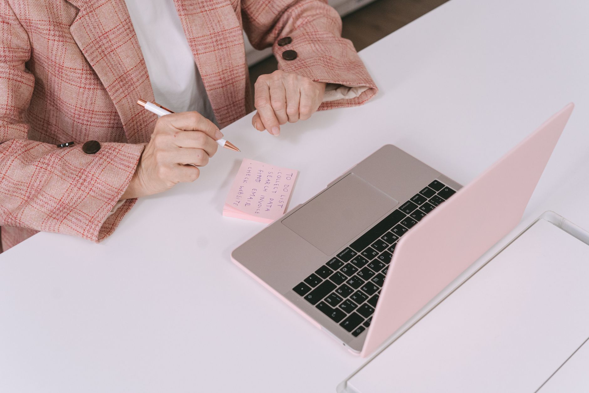 a life coach on a laptop preparing coaching session notes with a planner and coffee nearby