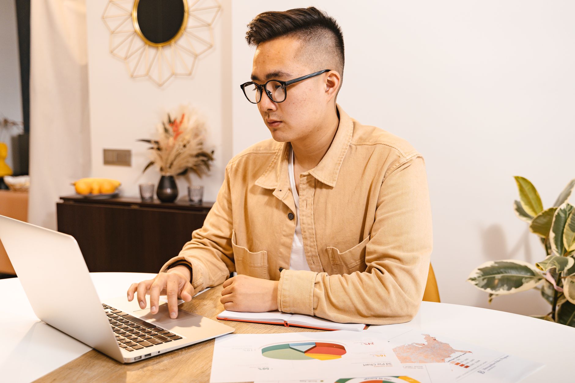 a consultant using a laptop with charts and documents in an office