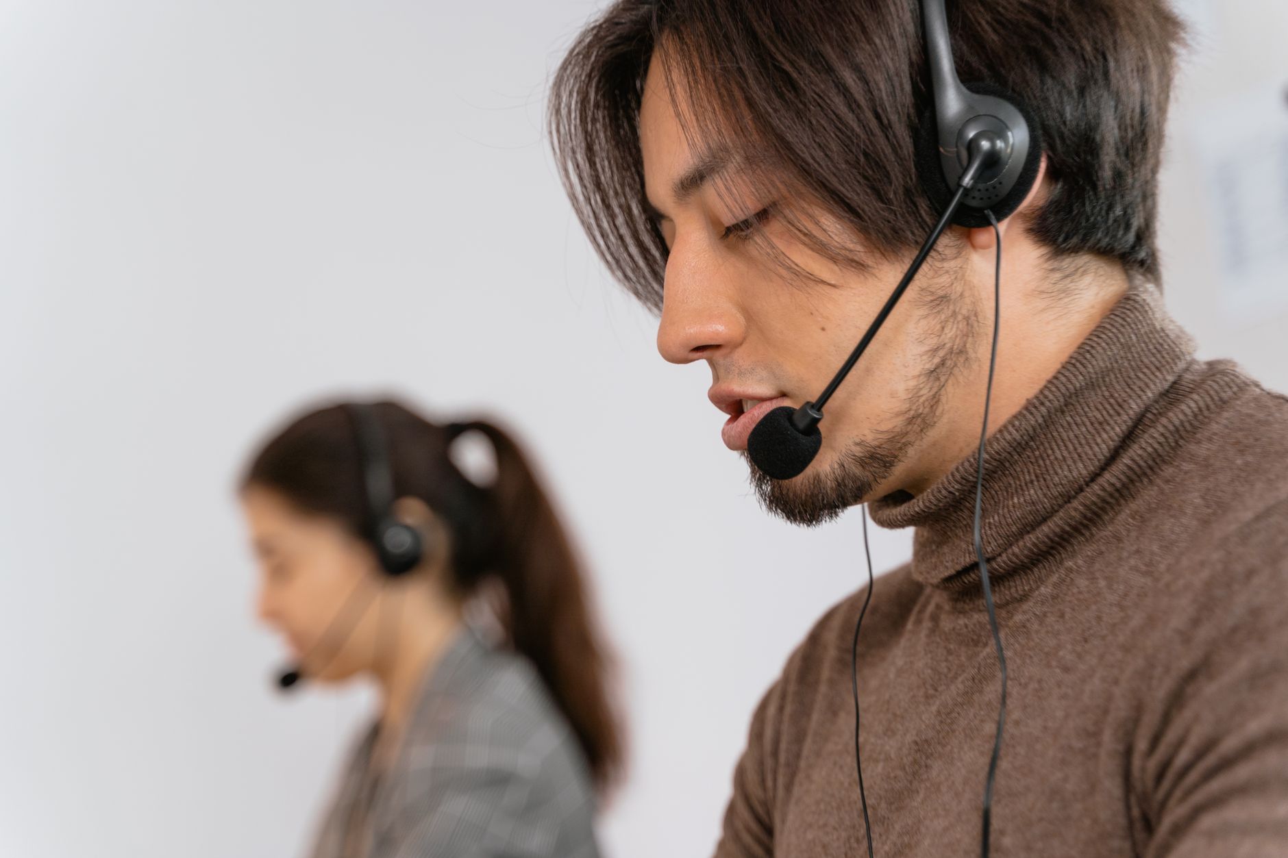 a call center agent wearing a headset and talking to a customer while looking at a computer screen