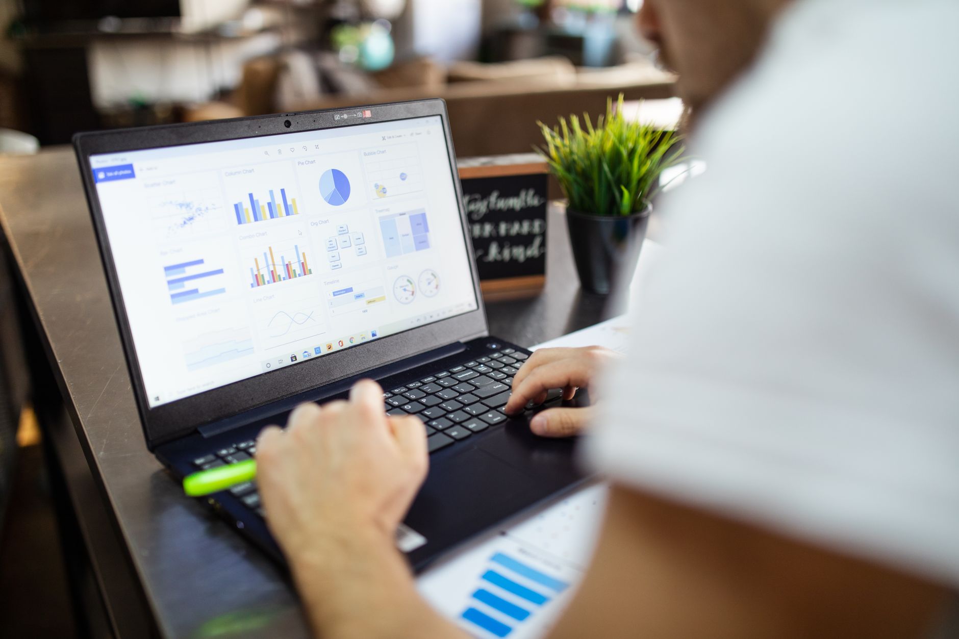 a person viewing data charts on a laptop screen with a spreadsheet open