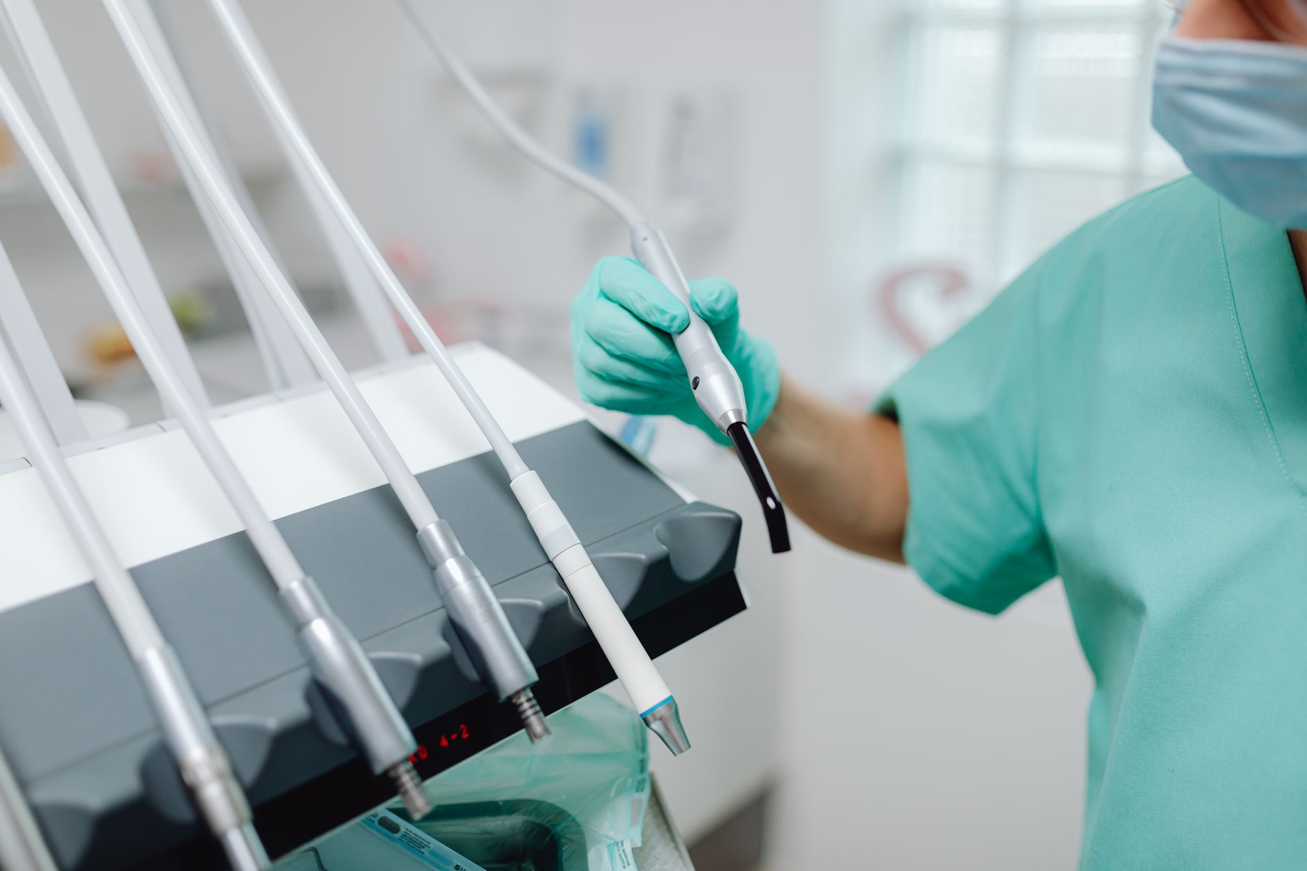 dentist wearing a headset and speaking into a microphone while viewing a patient chart on a dental practice screen