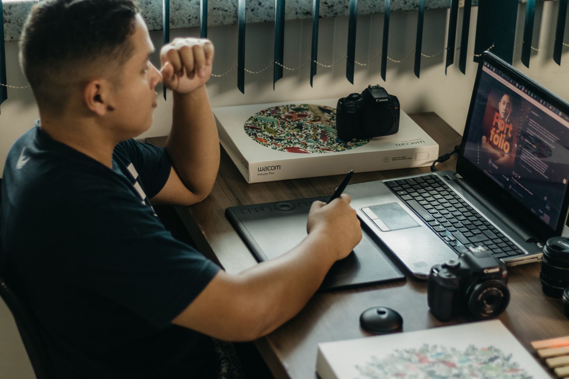 a graphic designer editing social media layouts on a laptop in a bright studio