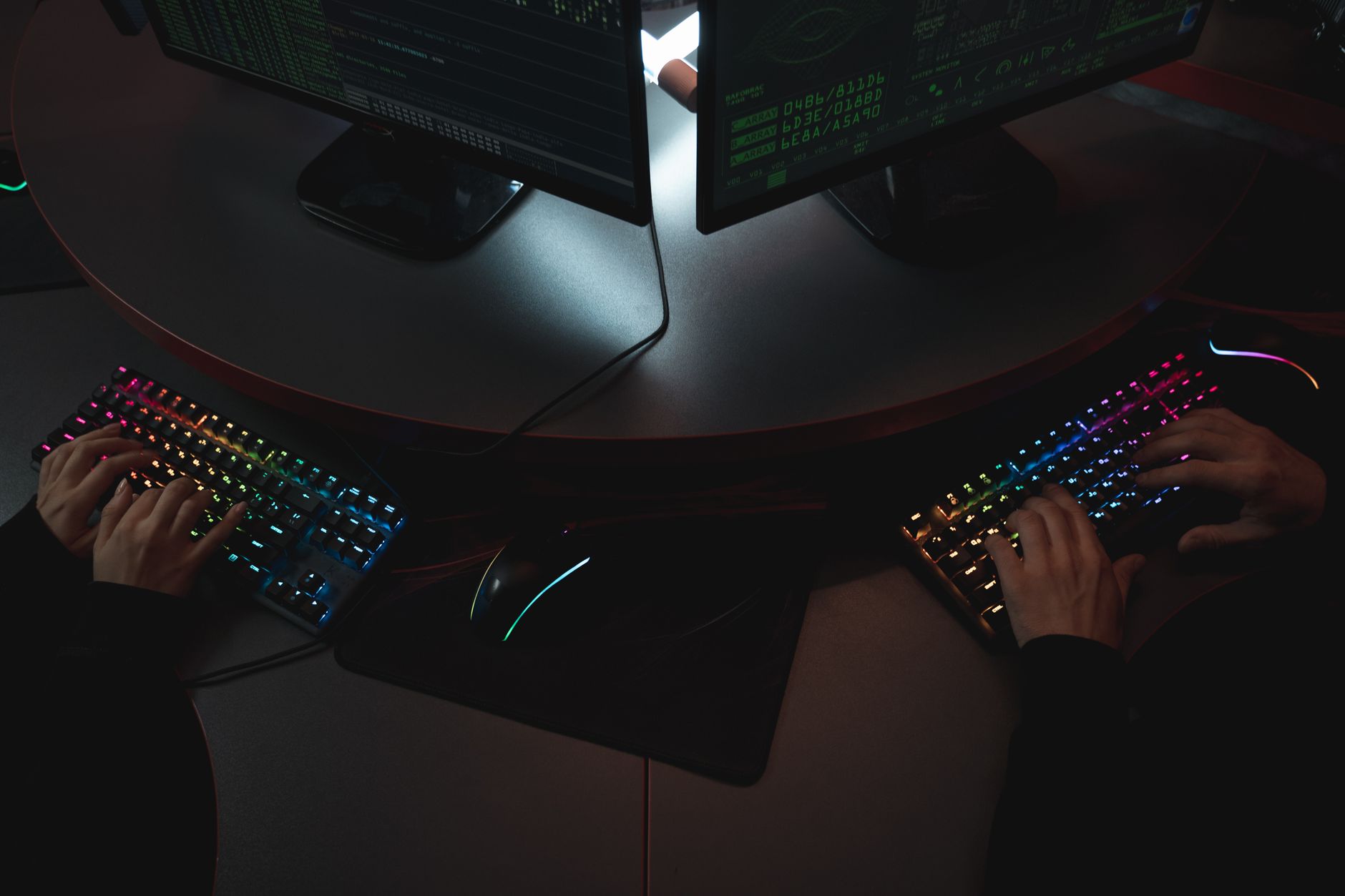 a programmer using a modern AI code editor on dual monitors with code on screen