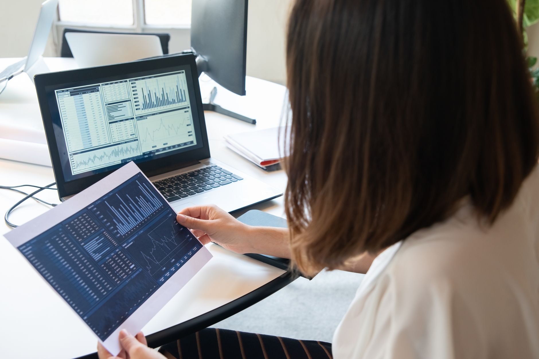 a marketer reviewing email campaign analytics on a laptop in a modern office