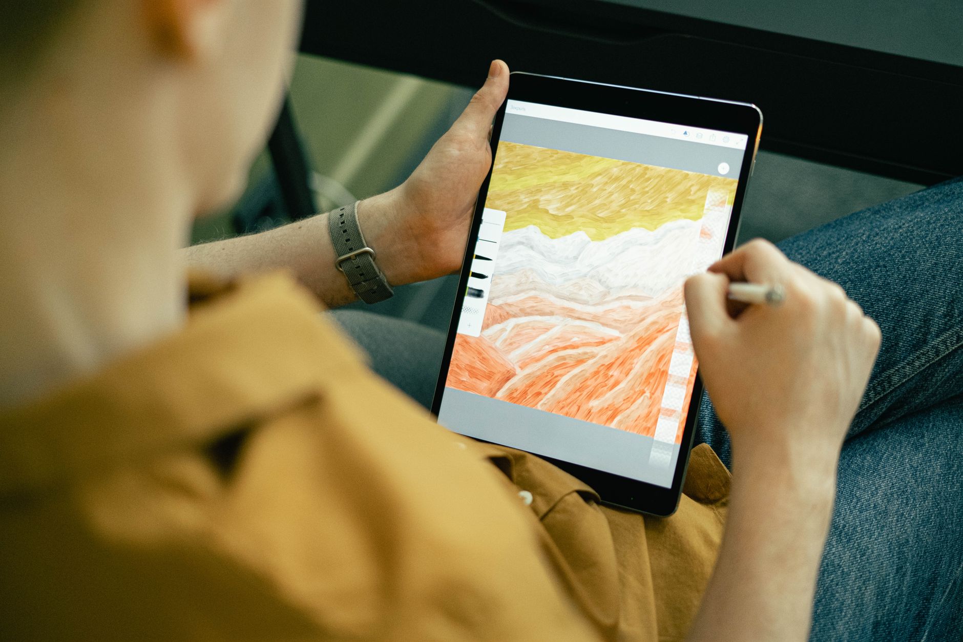 a digital artist drawing a colorful illustration on a tablet with a stylus