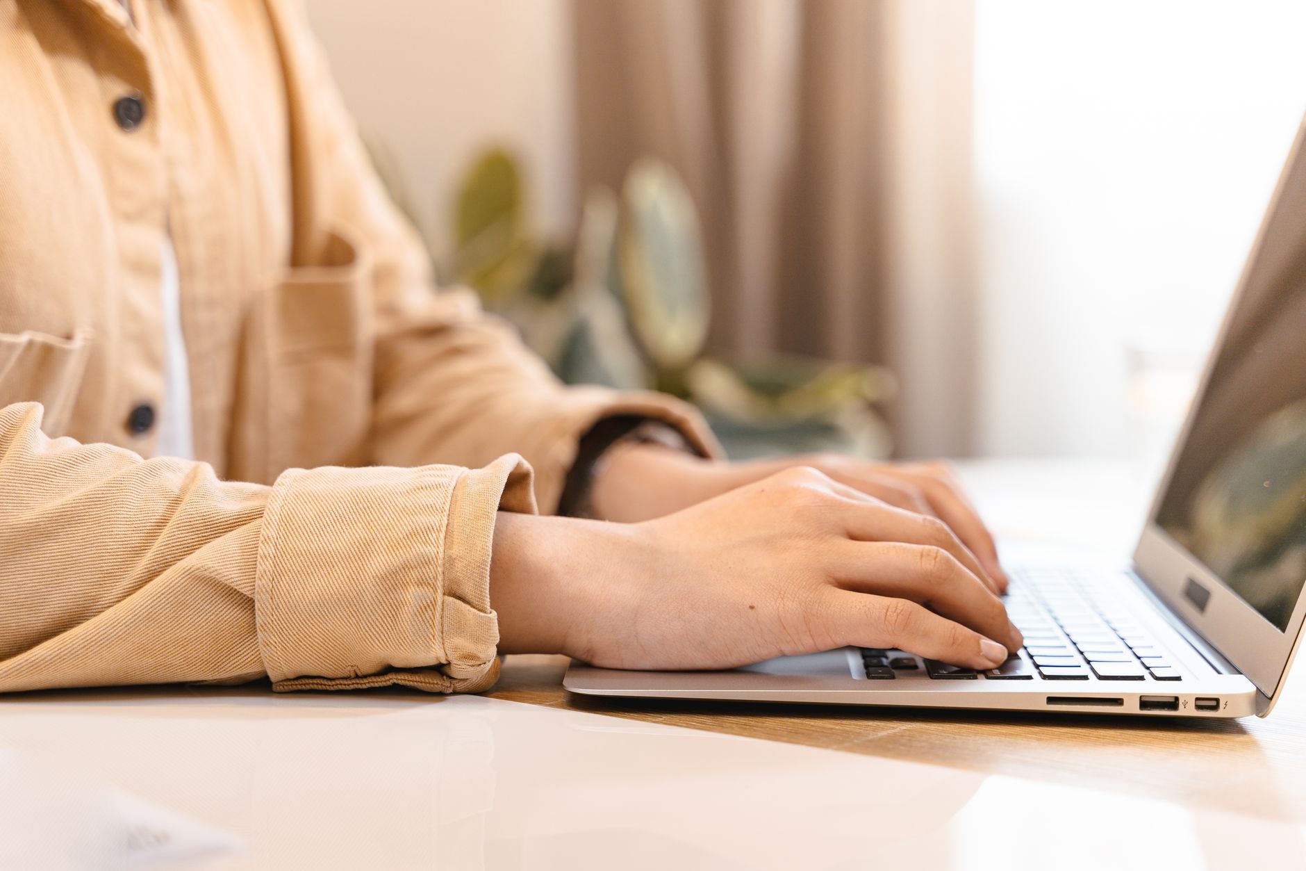 a close up of hands typing invoice line item descriptions on a laptop keyboard