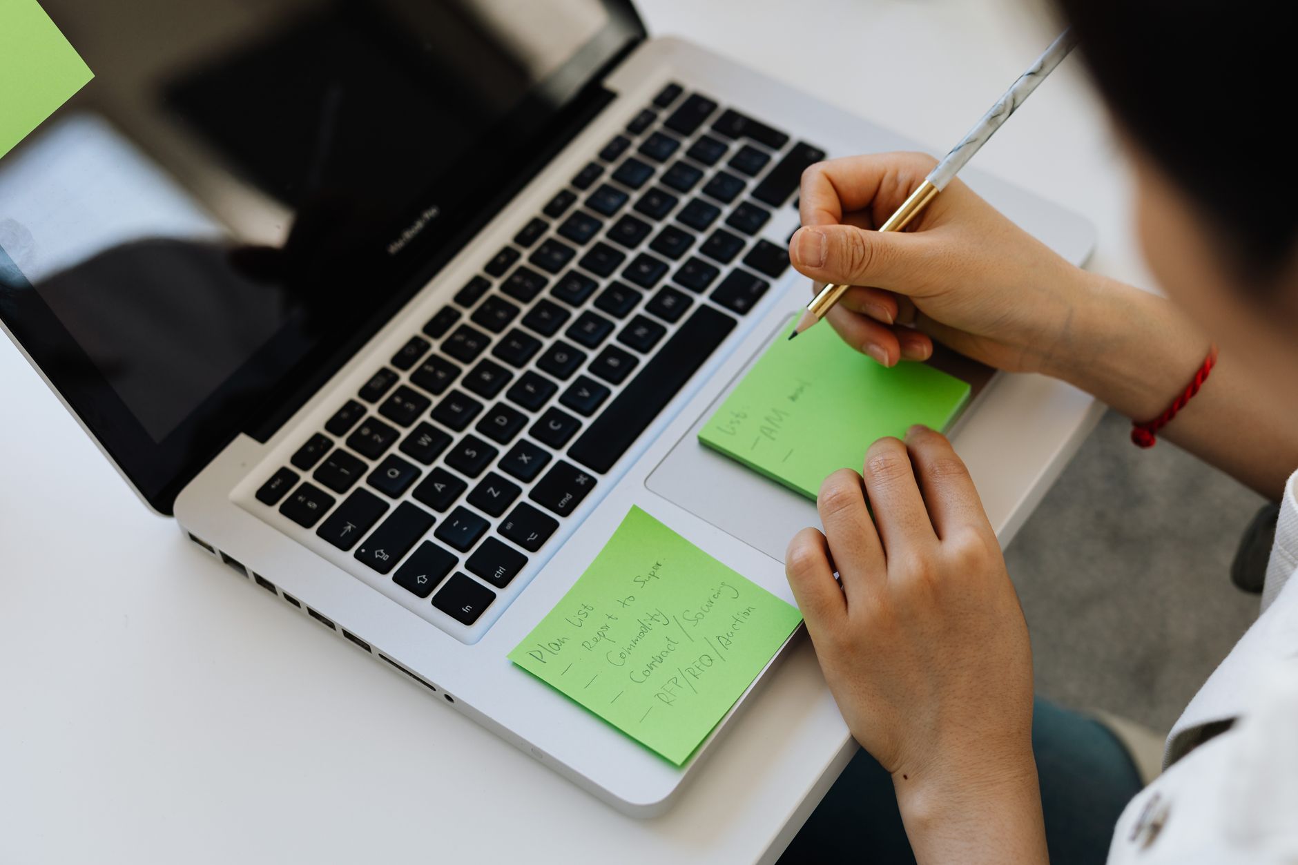 a person typing notes on a laptop with an organized note-taking app on screen