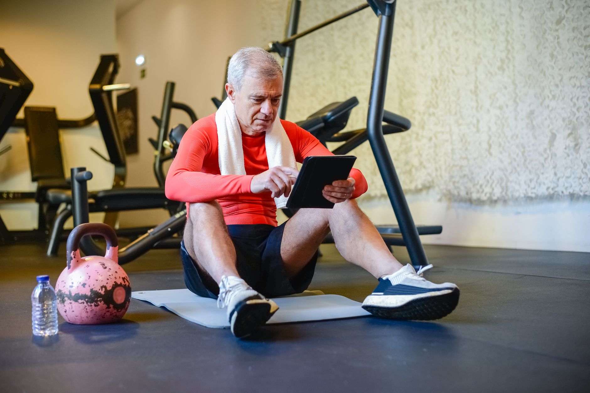 personal trainer writing workout plan on a tablet in a gym