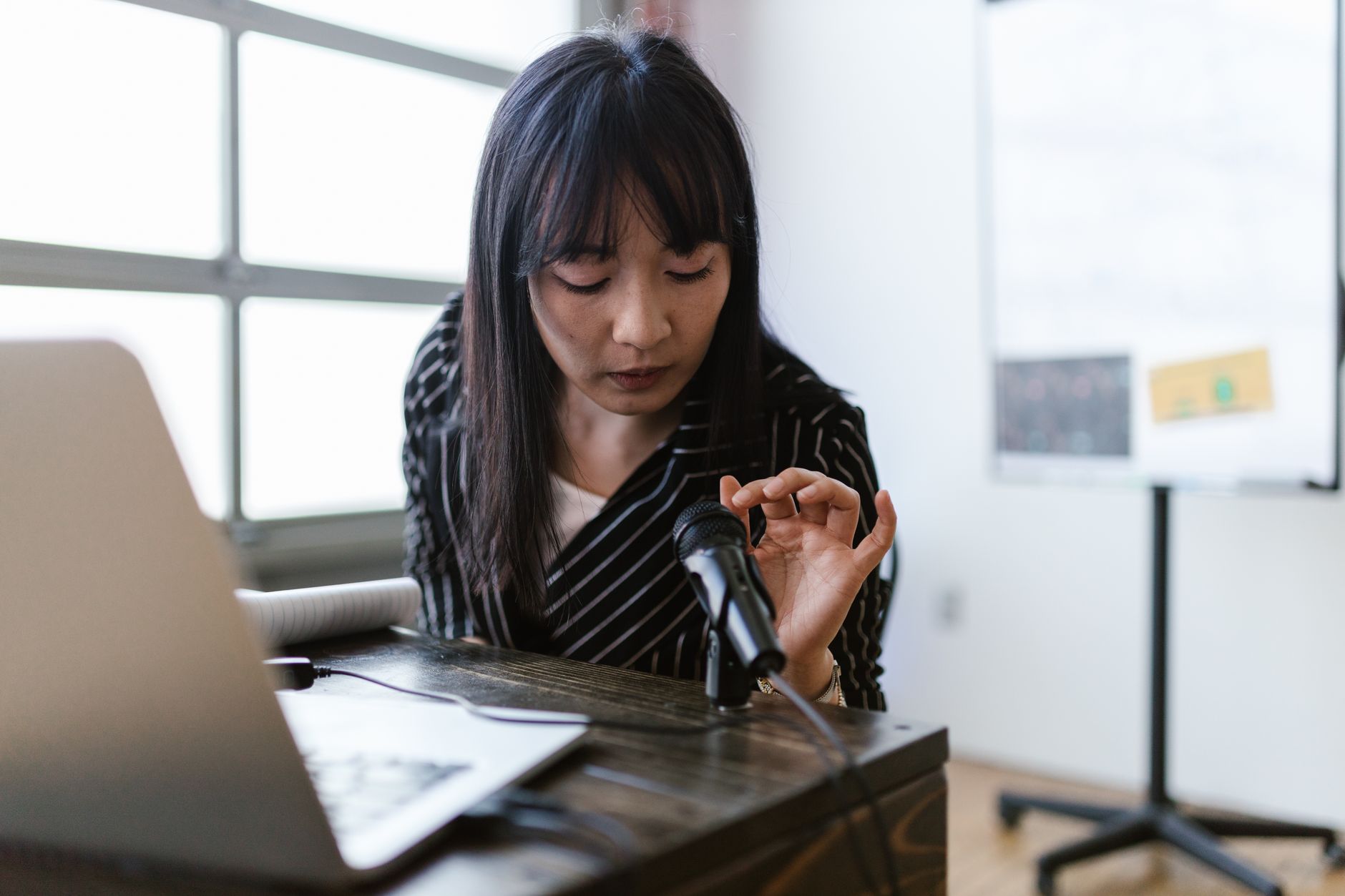 a business professional rehearsing a presentation using a laptop webcam