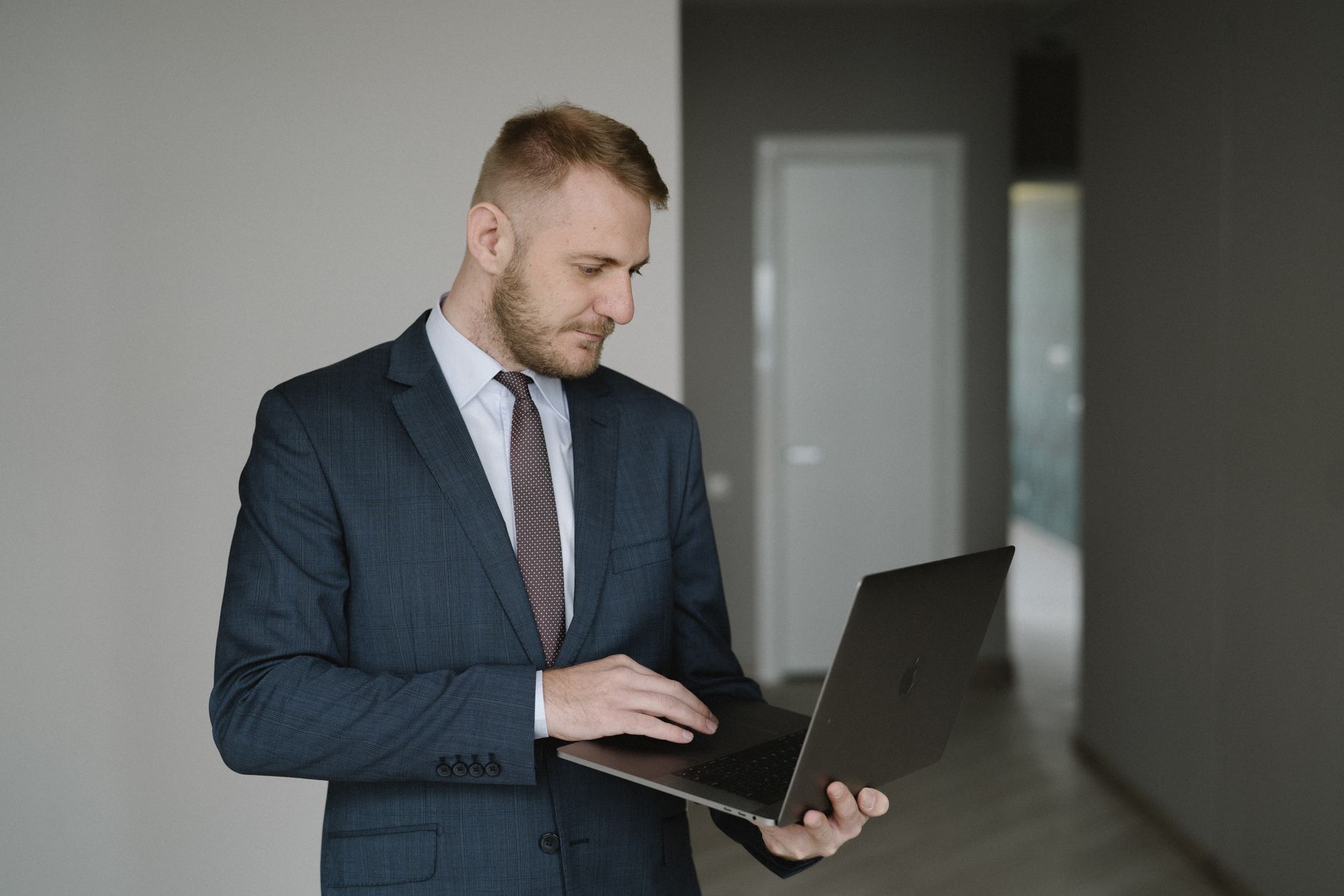 A real estate investor reviewing property listings on a laptop at a desk
