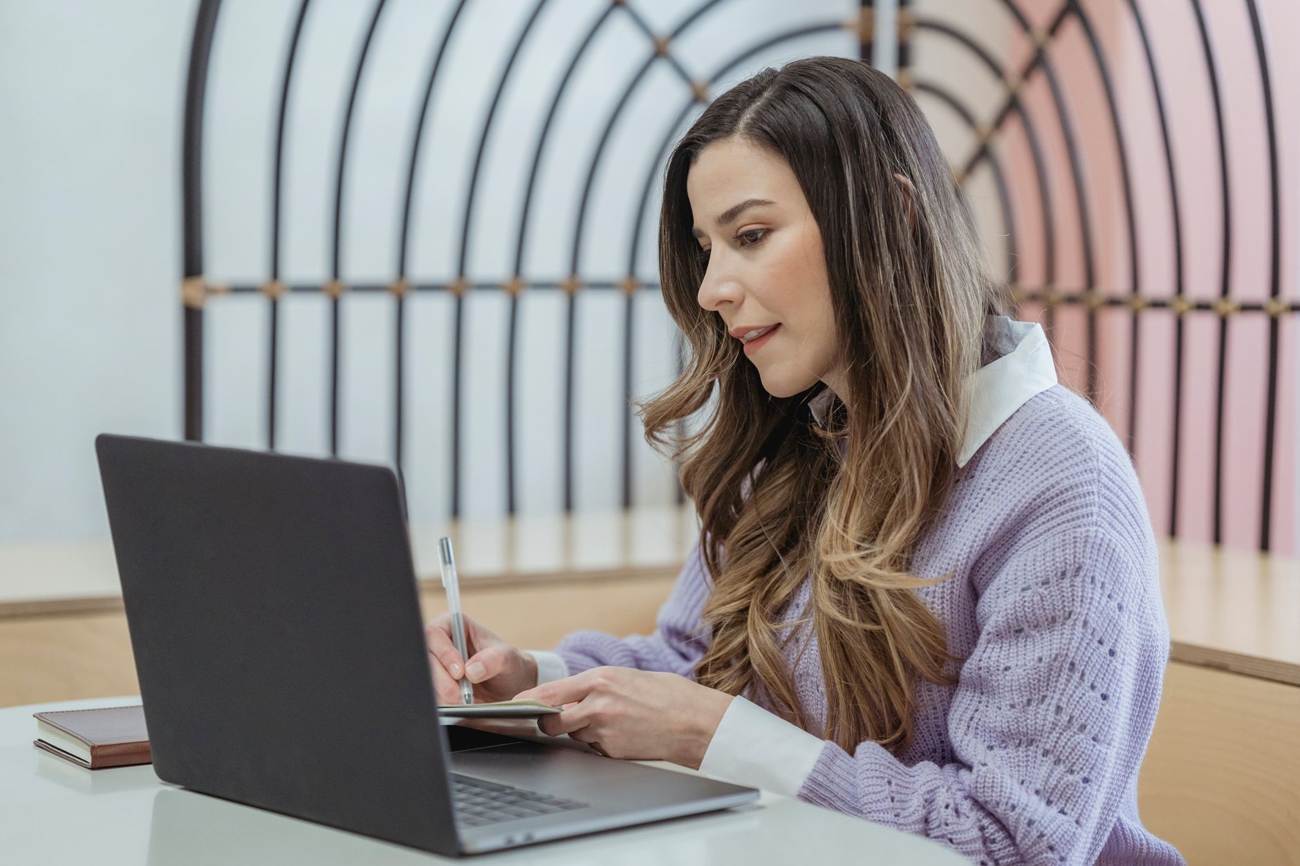a recruiter typing a job description on a laptop in a bright office