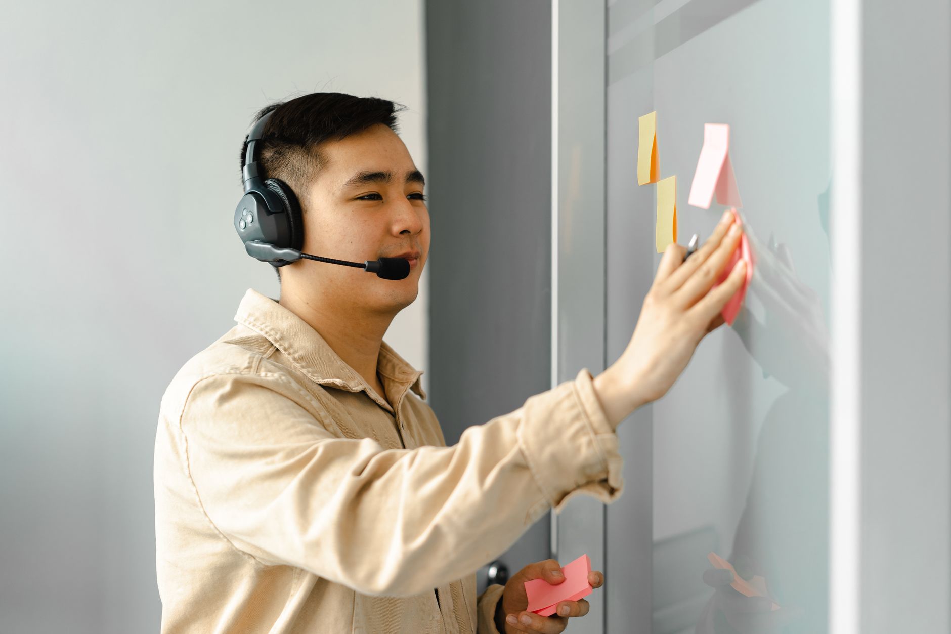 a sales manager wearing headphones and reviewing a call recording dashboard on a monitor