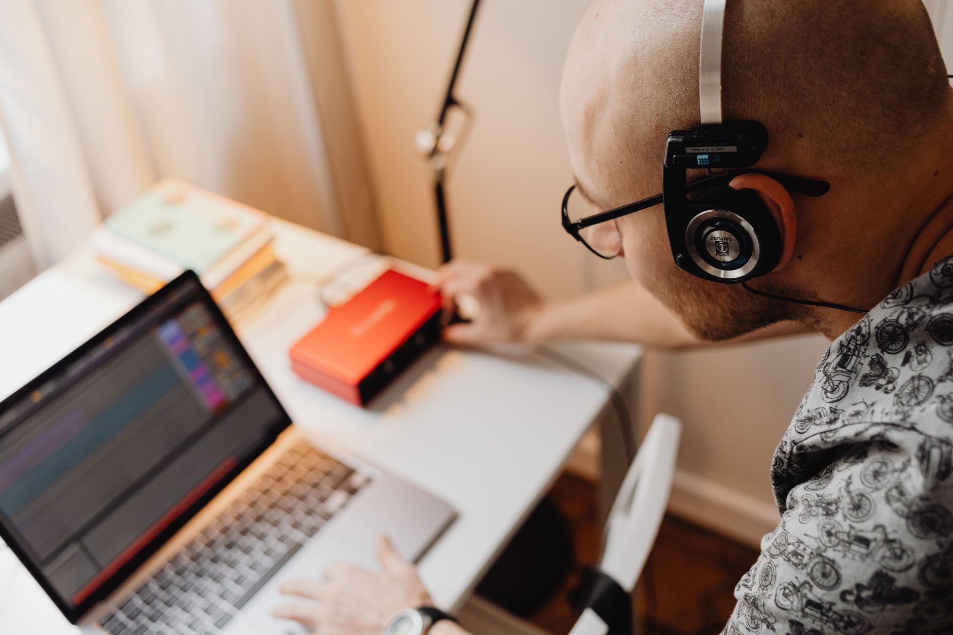 a person editing audio waveforms on a laptop with headphones in a recording studio