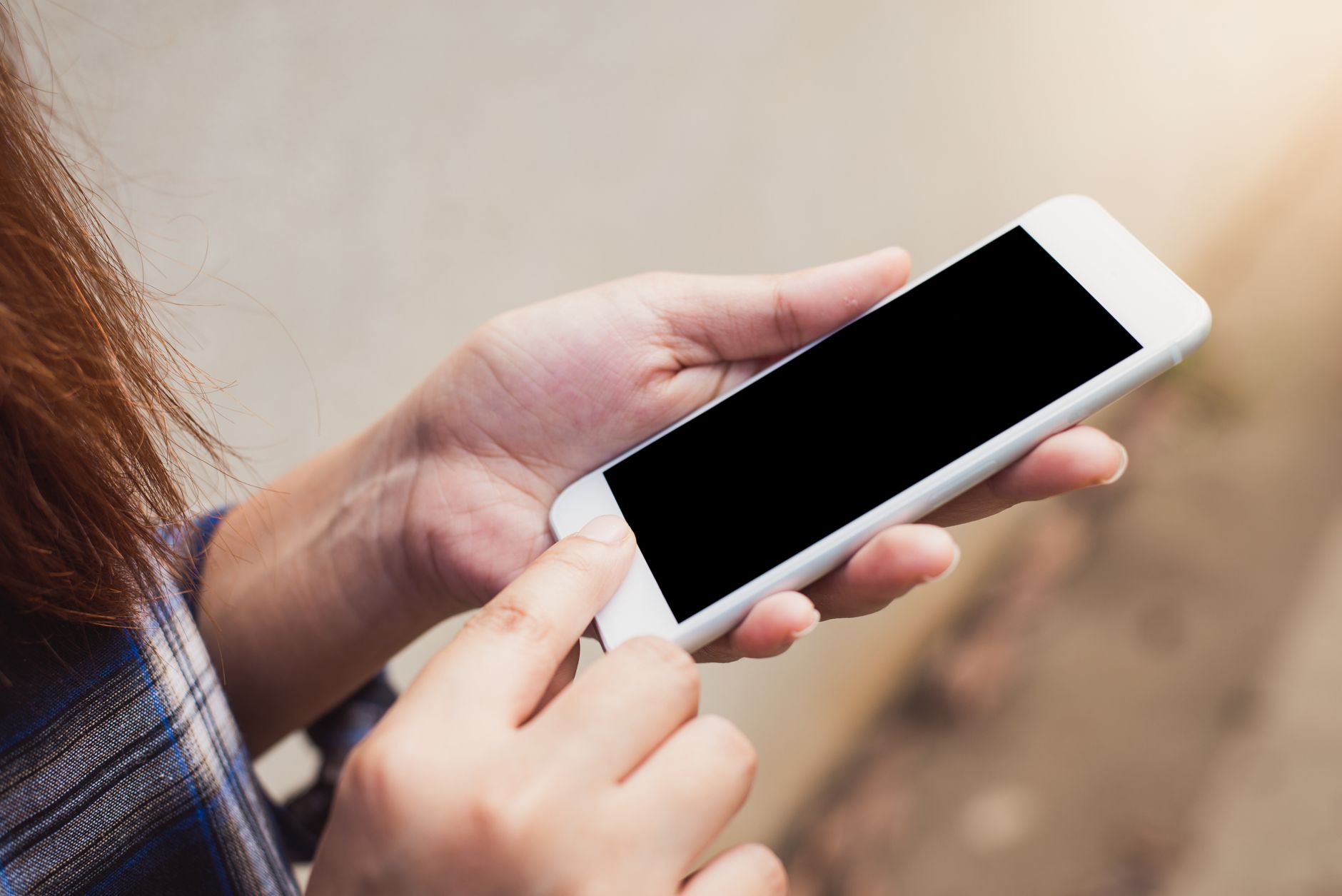 a person using a translation app on a smartphone while looking at a foreign language sign