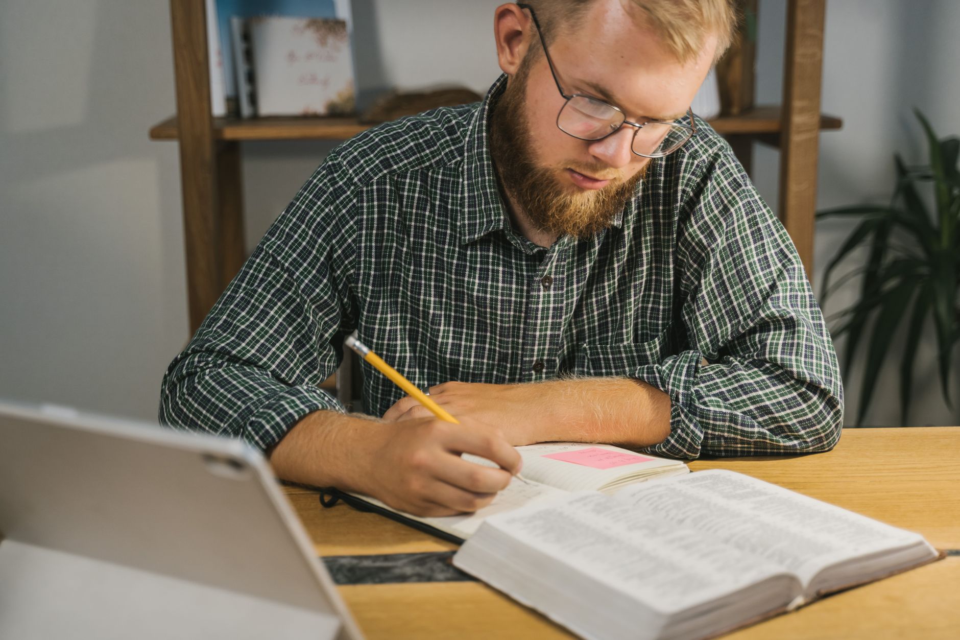 a researcher using a tablet surrounded by books and handwritten notes