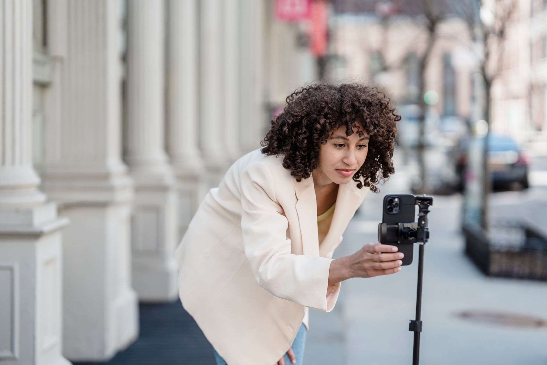 a content creator filming a vertical video with a smartphone on a tripod in a studio