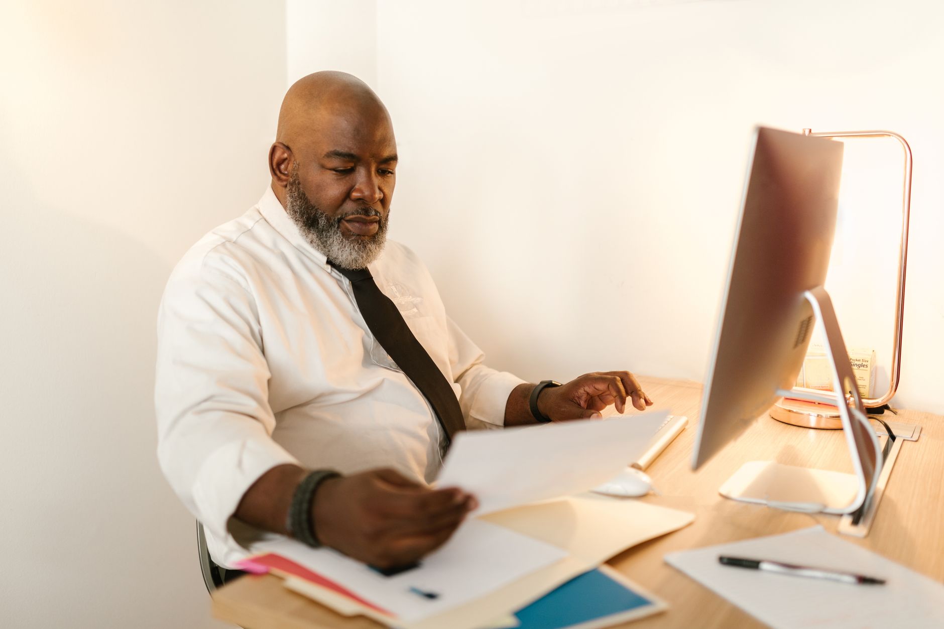 Professional reading a lengthy document on a large computer monitor in office