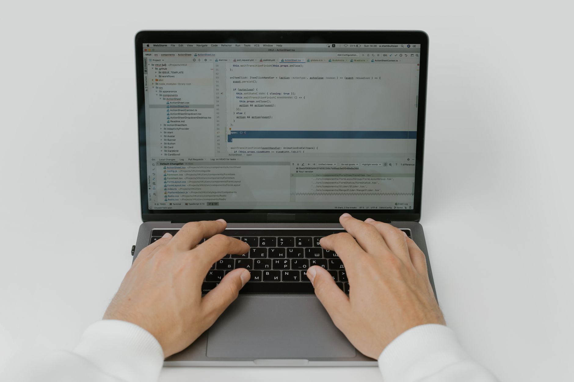 Person typing on a laptop while reviewing an AI written document