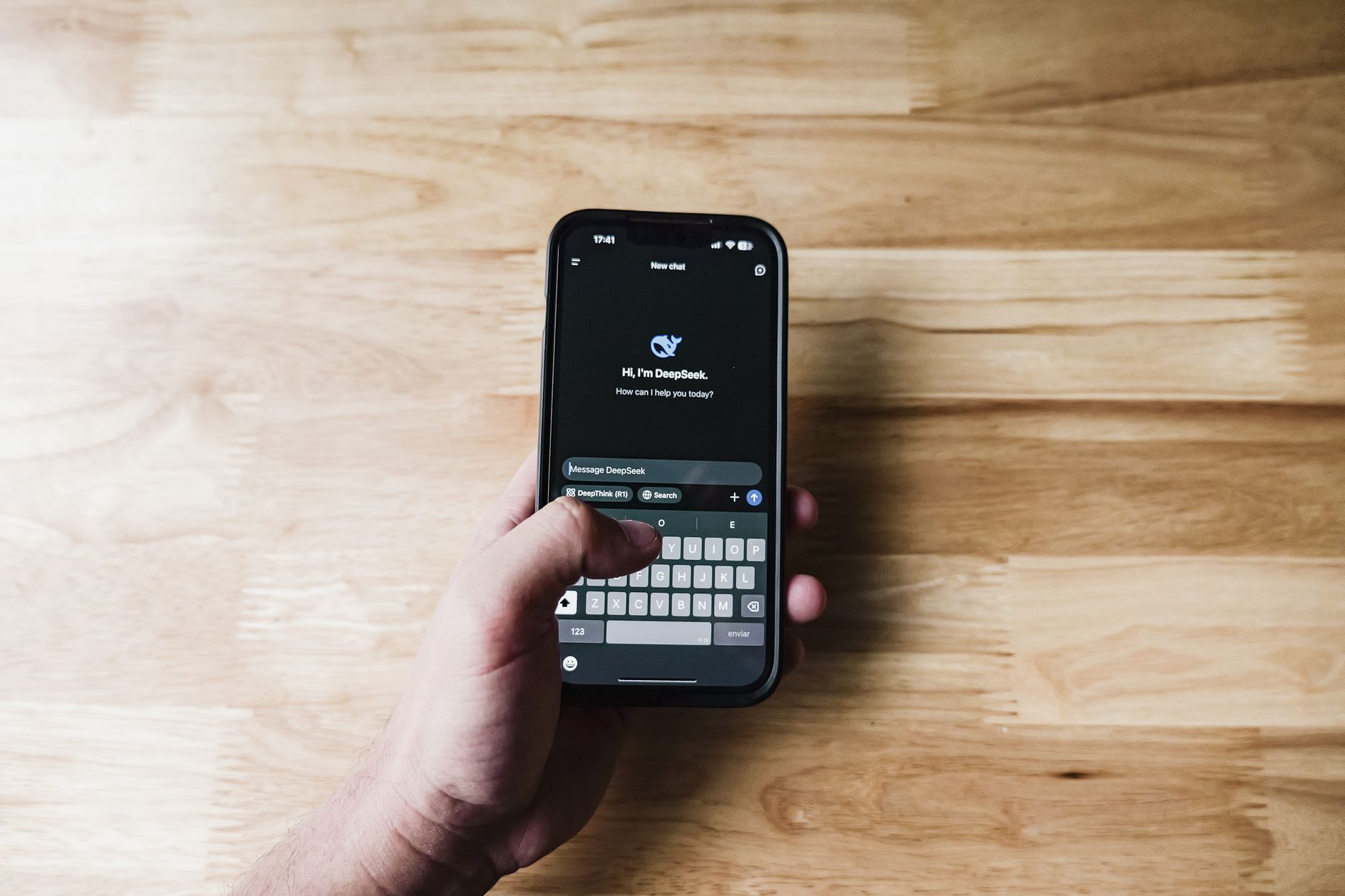 Person using a smartphone showing an AI assistant chat interface