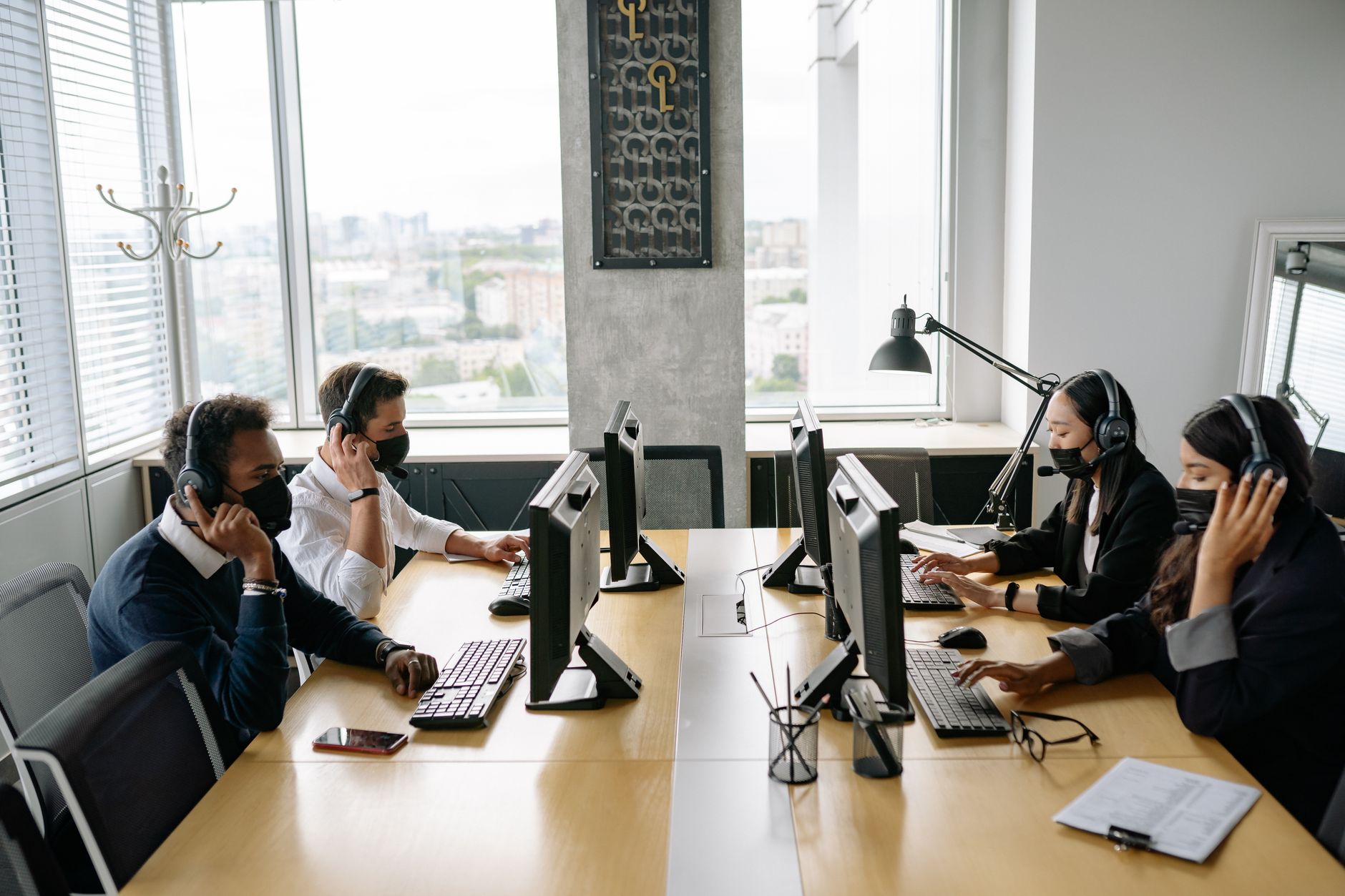 customer support team wearing headsets and working at computers in a modern office