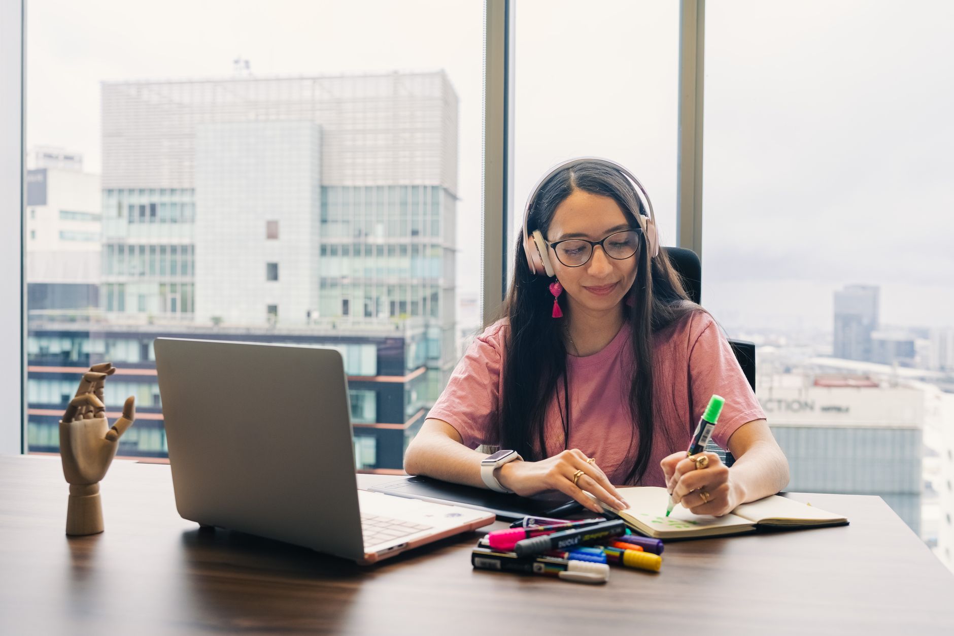 a student making flashcards at a desk with a laptop and colored index cards
