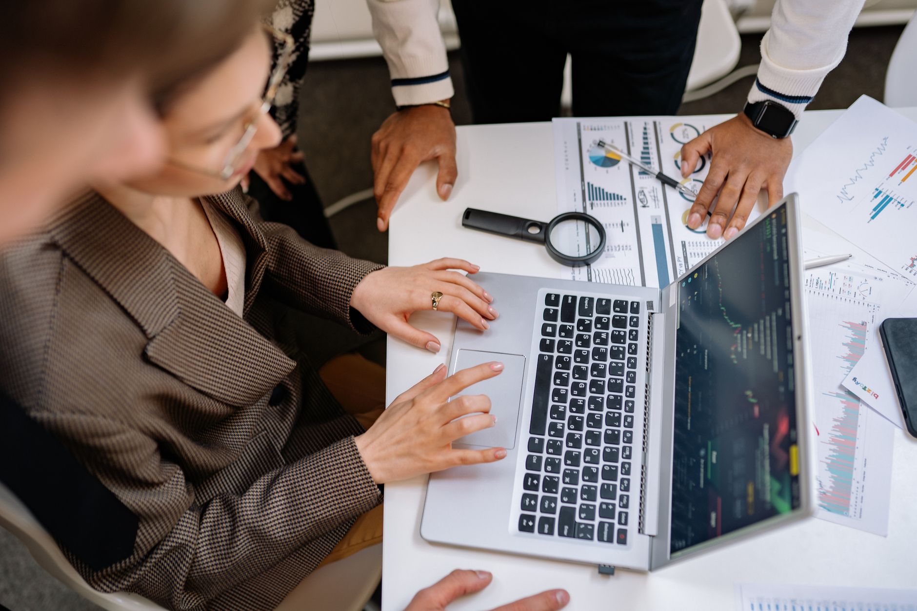 Marketing team discussing AI generated copy on laptop in modern office